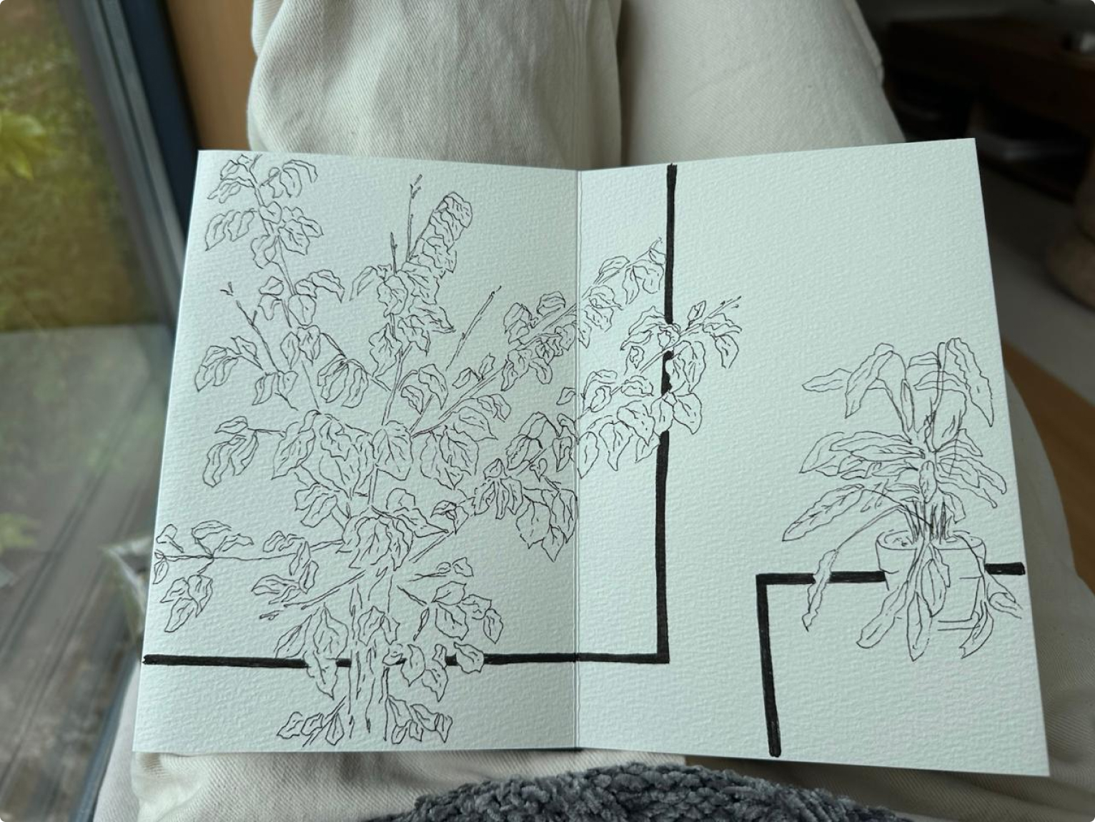 Ink drawing of flowers and leaves in a sketchbook